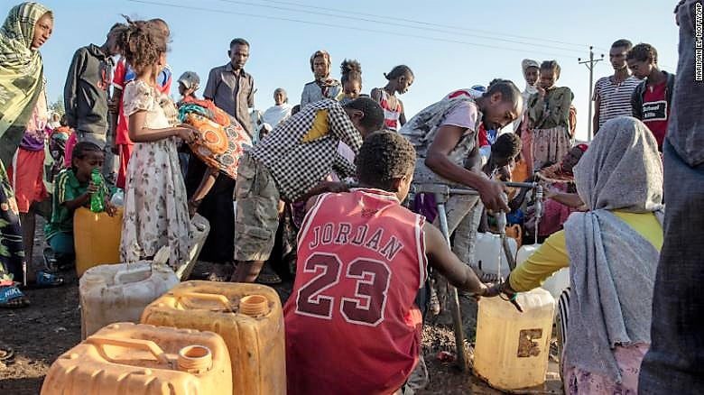 A refugee who fled the conflict in the Ethiopia's Tigray fills his gallon with water at Hamdeyat Transition Center near the Sudan-Ethiopia border