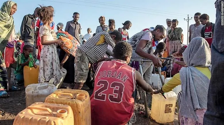 A refugee who fled the conflict in the Ethiopia's Tigray fills his gallon with water at Hamdeyat Transition Center